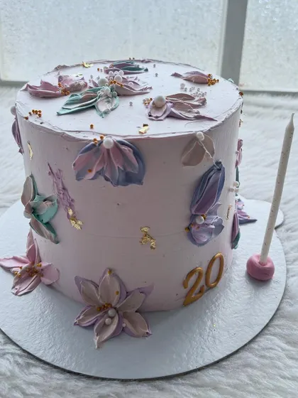 A dreamy cake for a 20th birthday, decorated with delicate, hand-piped palette knife flowers in pastel shades. A touch of gold leaf adds a bit of sparkle.