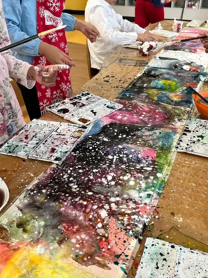 A beautiful, galaxy-like painting created by a student. We encourage experimentation with techniques like salt on watercolor to create stunning effects.