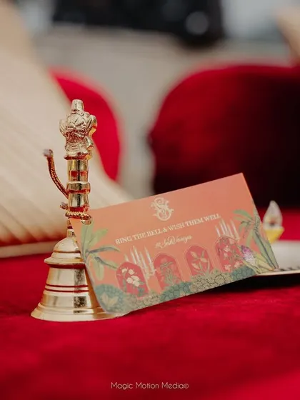 A small brass bell and a custom-printed card are placed on each guest's seat.