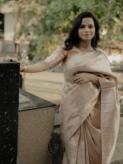 A classic and graceful portrait, showcasing the simple elegance of the saree and the subject's gentle smile.