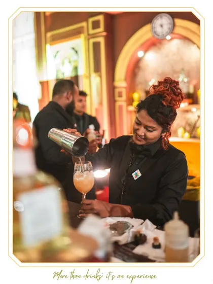 Our talented female mixologist pours a freshly shaken cocktail with a smile. We pride ourselves on having a diverse and highly skilled team ready to elevate your event.