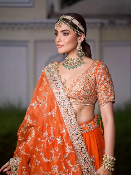 Orange is the new red. This Abhinav Mishra lehenga is a fresh and vibrant choice for a modern bride. I paired it with a contrasting green emerald choker and a statement matha patti for a bold, fashion-forward look.