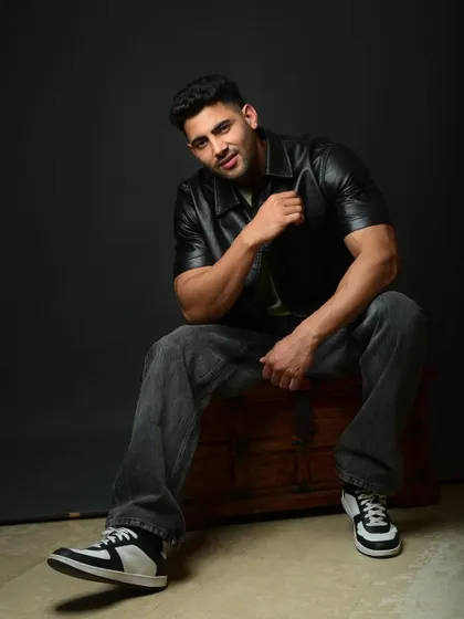 A relaxed yet powerful seated pose for a fitness model. The low angle and confident expression create a strong and impactful image.