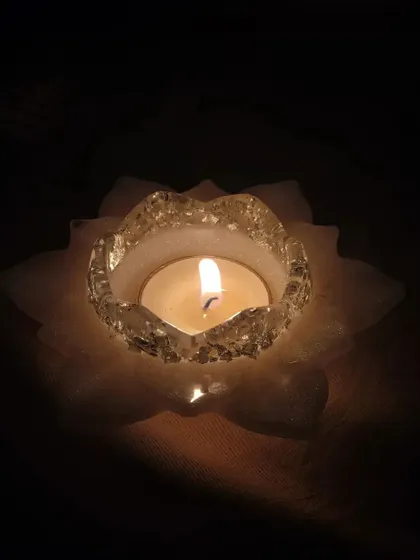The lotus T-light holder glowing in the dark. The light shines through the resin petals, creating a soft and magical ambiance.