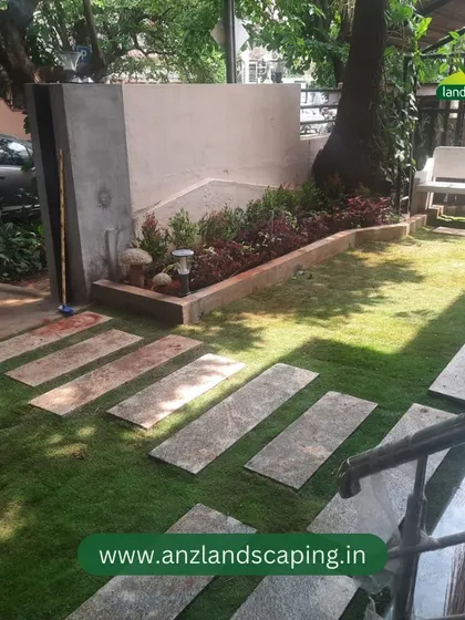 The view from the side showcases the stone bench and mature trees we incorporated into the garden design, creating a shady and relaxing corner.