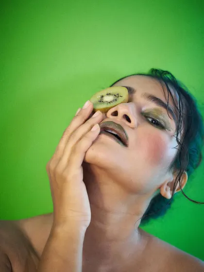 An artistic and high-fashion pose with a kiwi slice. This demonstrates my versatility, moving from commercial looks to more editorial and abstract concepts.