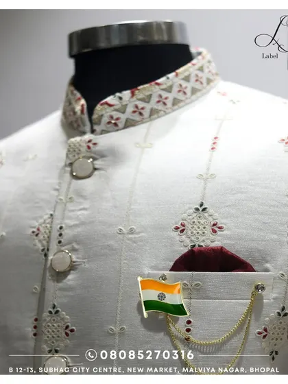 Details matter. This is a close-up of the fine embroidery and unique button work on one of my custom white Bandis. The fabric has a subtle texture, and the collar features a contrasting pattern, showing the thought that goes into every element.