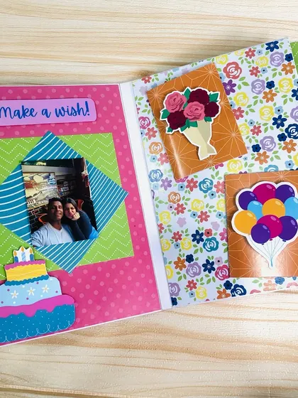 This scrapbook page has a "Make a wish!" theme, with a birthday cake sticker and pockets to hold small, surprise photos or notes.