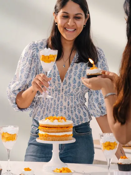 A candid moment of celebration, showing friends enjoying a birthday with cake and treats. This lifestyle image brings a human element to the festive food setup.