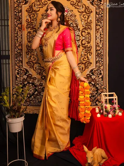 A full-length shot of a model in a beautiful golden saree. The traditional setting with a patterned rug and candles adds to the classic, elegant feel of this portfolio shoot.