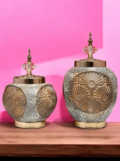 This pair of decorative jars combines a rustic, textured finish with an elegant gold floral pattern. The crystal-topped lids add a touch of luxury, making them beautiful accent pieces.