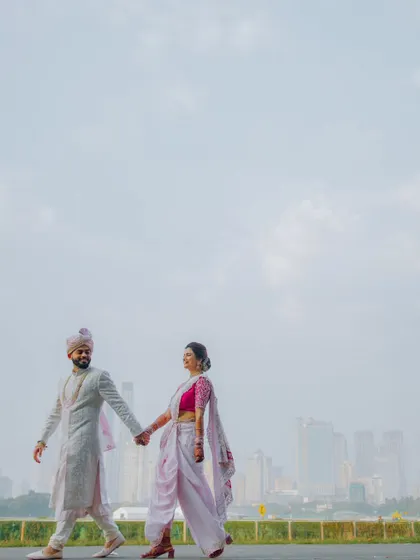A beautiful, wide-angle shot of the couple walking hand-in-hand, with the expansive city skyline as their backdrop.