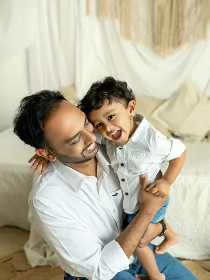 The pure, unadulterated joy of a little boy laughing while being held by his dad. These are the energetic, happy moments that define childhood.