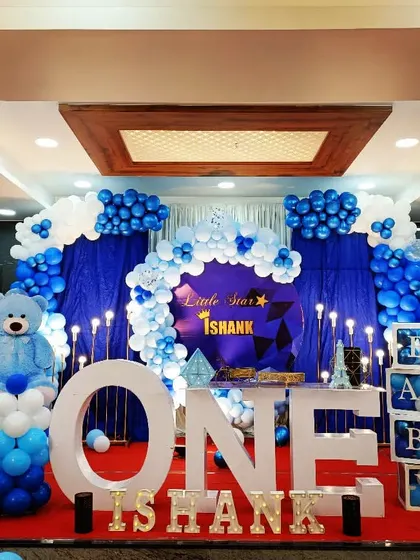 A "Little Star" first birthday for Ishank. This classic blue and white theme features a large teddy bear, "ONE" marquee letters, and a star-studded backdrop.