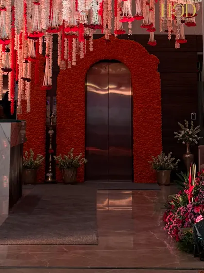 A wider view of the marigold-arched elevator entrance, showing how it integrates with the hanging floral decor of the main hall. This creates a seamless and beautifully themed experience from the moment guests arrive.
