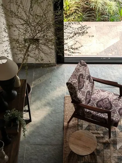 An overhead view of the living area in Maison Rouge, showing the interplay of light and shadow. The design uses traditional furniture and decor to create a space that feels authentic and deeply connected to the family's roots.