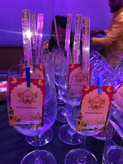 Custom-designed tags and stirrers for a wedding. These details carry the event's theme and hashtag right to the cocktails.