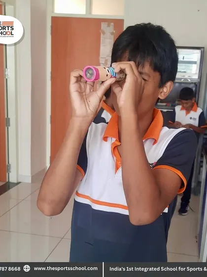 A student peers through a kaleidoscope he made, learning about reflection and patterns in a fun, interactive way.
