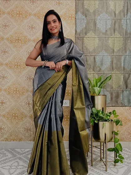A classy grey tissue saree with a gold border. This is a very modern and chic color for a traditional fabric, perfect for an evening event.