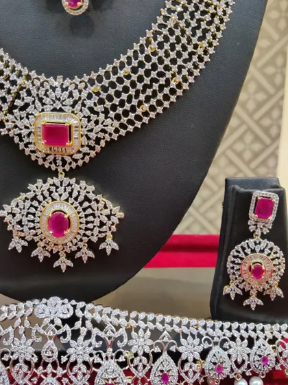 A close-up of a beautiful American diamond and ruby set, showing the intricate details of the necklace and earrings.