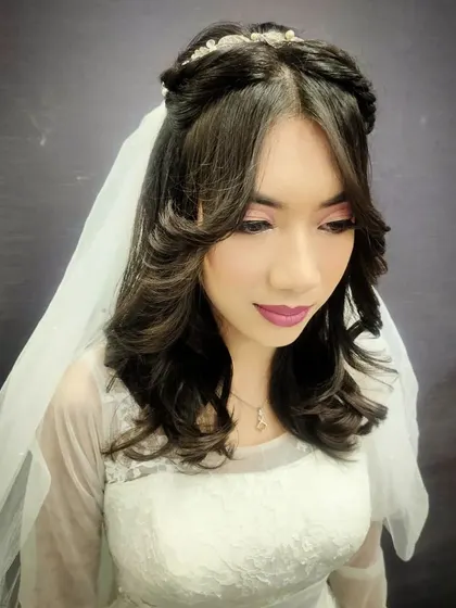 This image shows the detailed hairstyling and accessory placement that completes the Christian bridal look.