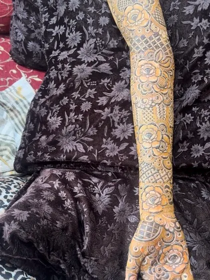 A close-up of a bridal floral design on the arm. The shading within the flowers and the precise lattice work showcase the level of detail that goes into each bridal application.