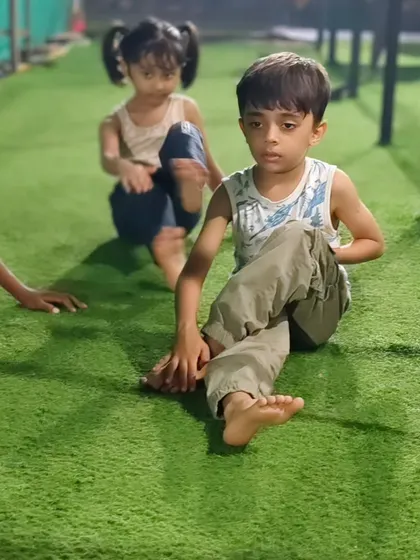Two of our youngest members work on a seated spinal twist, a simple but effective yoga pose for improving flexibility in the back.