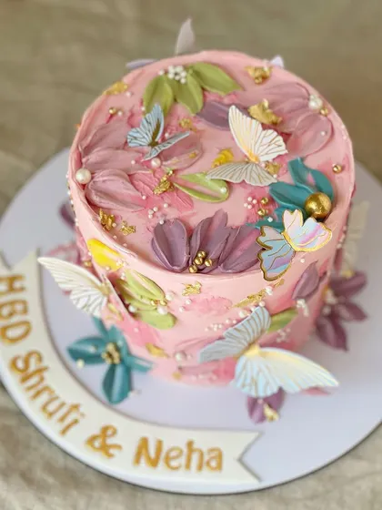 A top-down view of the pink butterfly cake, showing the artistic arrangement of flowers and butterflies.