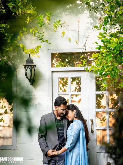 A romantic and cozy moment shared by a couple in front of a charming white door.