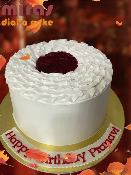 A simple yet beautiful raspberry cake. The white cake features a ruffled frosting texture and a well of raspberry filling on top, letting the fresh fruit flavor be the star.