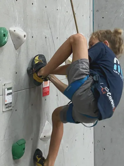 A young climber uses advanced foot technique, hooking his heel to maintain balance. It's amazing to see kids pick up complex skills so quickly.