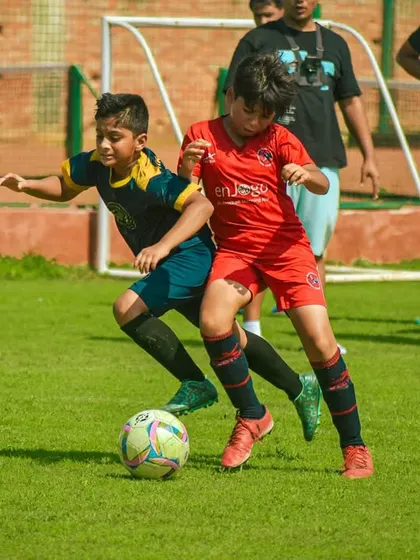 Two players in red and blue kits battle for possession.