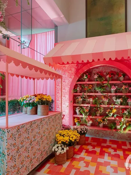We designed a charming flower market stall as a decorative feature. The structure, with its scalloped awning and patterned counter, was filled with fresh blooms, adding to the Italian market atmosphere.