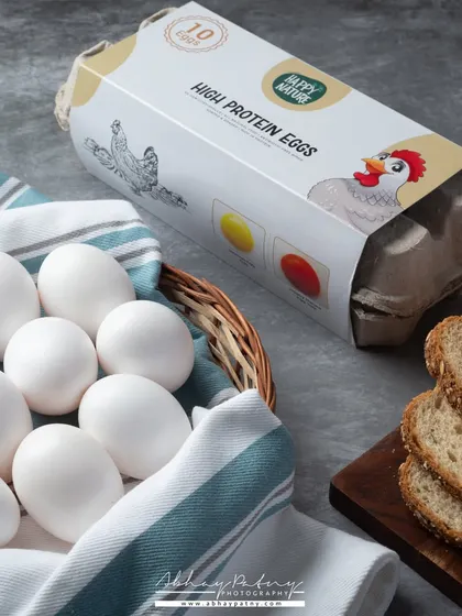 This shot for a carton of high-protein eggs uses a clean, natural style. Including the bread and a simple basket creates a breakfast context, helping customers visualize the product in their daily lives.