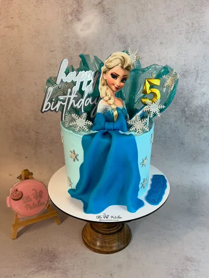 Let it go with this beautiful Frozen-themed cake for a 5th birthday. It features an edible Elsa figure, delicate sugar snowflakes, and an icy blue color palette.