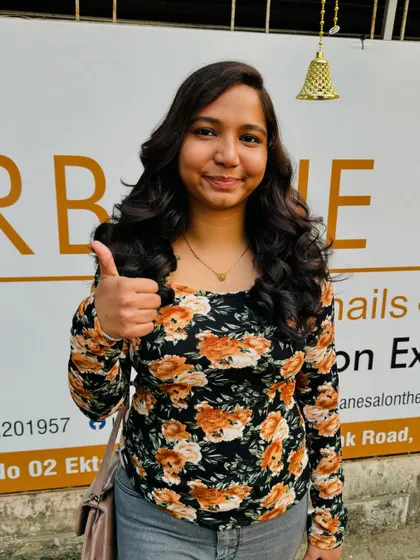 A thumbs-up from a happy client. Her new global colour and style have given her a fresh, confident look.