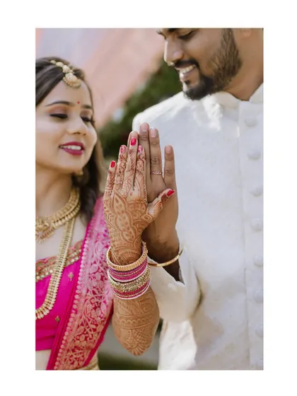 A creative shot focusing on the bride and groom's hands, showcasing the intricate henna and the newly exchanged rings.