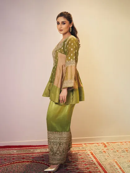 This regal peplum sharara set is a great example of Indo-Western fusion, styled for a cultural event. The silhouette is modern, while the embroidery is classic.