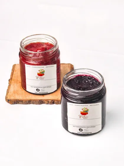 Two jars of handmade strawberry and blueberry jam, styled together for a clean e-commerce or product catalog shot.