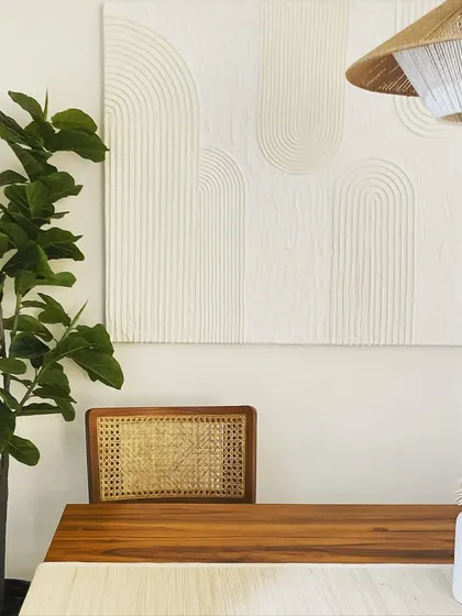 This dining area is inspired by Scandinavian design, with a focus on minimalism, natural materials, and muted colors. The textured wall art and woven pendant light add subtle interest to the clean, simple space.
