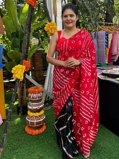 I love working with traditional prints like Bandhani. I designed this half-and-half saree with a red leheriya and black bandini pattern for a festive, contemporary look.