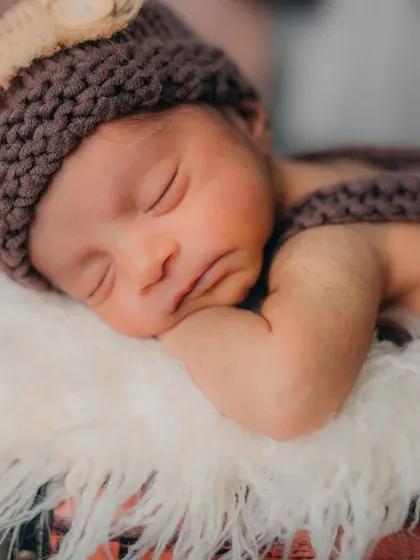 A tight close-up on the baby's peaceful, sleeping face. This shot is all about capturing the delicate features and serene expression of a brand new life.