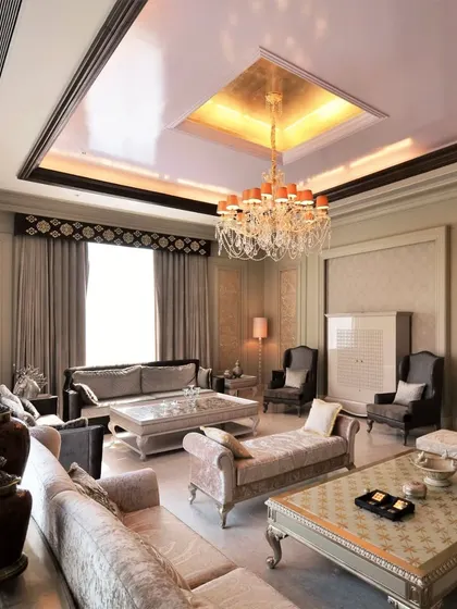 This living room showcases our work in a more classical style. It features ornate, hand-carved furniture, a crystal chandelier, and detailed wall paneling, all working together to create an atmosphere of timeless elegance and luxury.