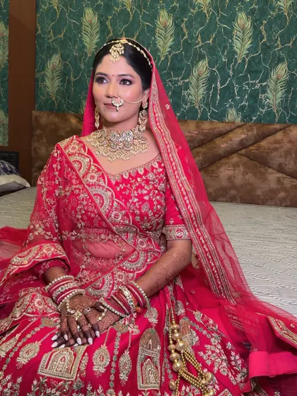 A quiet, contemplative moment before the ceremonies begin. The soft lighting highlights the beautiful glow and the intricate embroidery on her bridal outfit.