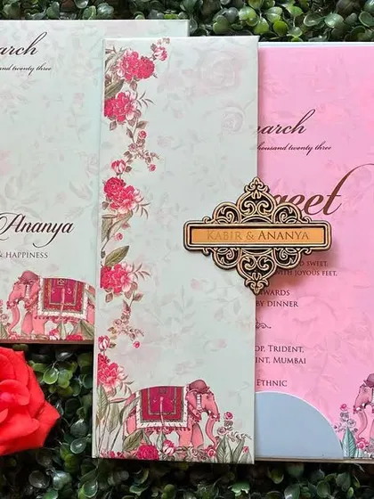 A beautiful gate-fold invitation with elephant motifs and floral borders. The pink and blue inserts add a pop of color.