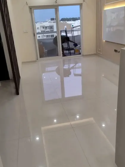 An empty room with freshly laid glossy tiles and new wiring, ready for the next phase of interior work. This shows the clean slate we begin with in our turnkey projects.