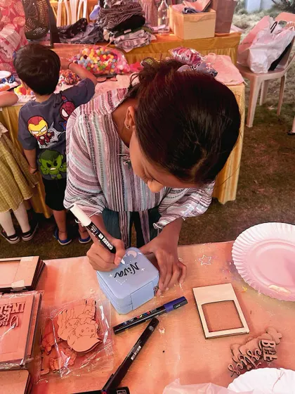 A close-up of a participant carefully writing a name on a box at our pop-up event.