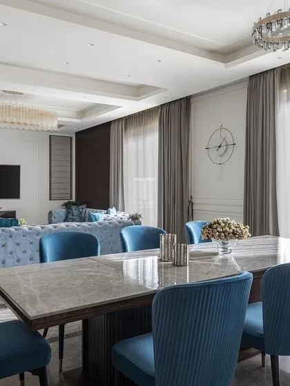 A view from the dining area into the living room, showing how we create a cohesive design language across open-plan spaces. The deep blue of the dining chairs echoes the sofas, tying the two zones together beautifully.