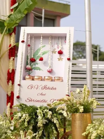 A beautiful welcome decor piece for a South Indian wedding, incorporating traditional elements like banana leaves, brass bowls, and floral hangings.