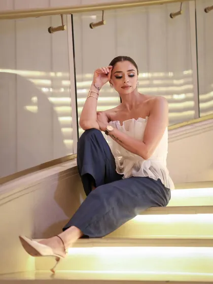 A duplicate of the relaxed pose on the stairs. It reinforces the consistency of the makeup application, looking great from multiple angles and shots.